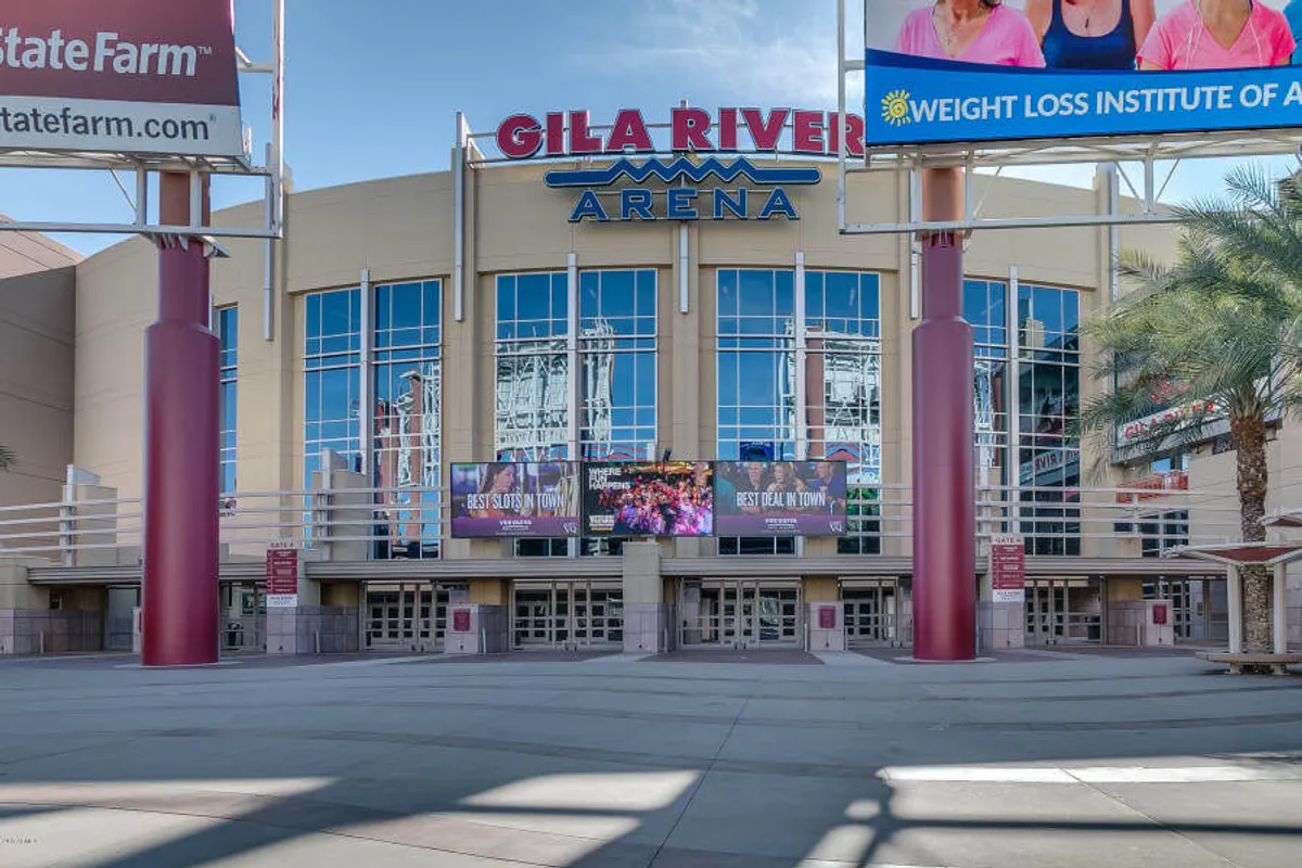 This image features the Gila River Arena sign, expansive glass windows, and digital billboards, immediately conveying the excitement and scale of major sports and concert events within the Glendale area. The busy exterior and dynamic signage evoke the thrill of attending live entertainment close by.